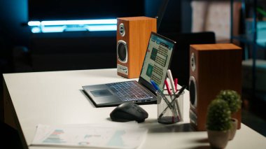 Çağdaş aydınlatılmış bir dairede boş ama davet edici bir ofis. Ahşap döşemeler, modern mobilyalar ve dekoratif bitkiler kapalı alanda çalışmak için rahat bir çalışma alanı oluşturuyorlar..