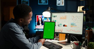 Bir program için fon araştıran ve tablet tutan genç bir adam, bir yazılımda finans ve muhasebe yönetimi okuyor. Başlangıç için uzaktan kumandalı iş yapan bir erkek uzman. Kamera A.