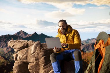 Doğayı seven işkolik her zaman internete bağlanır ve dizüstü bilgisayarda kayar, nefes kesen manzaralı dağın tepesinde güçlü bir sinyalin tadını çıkarır. Kesintisiz çalışma.