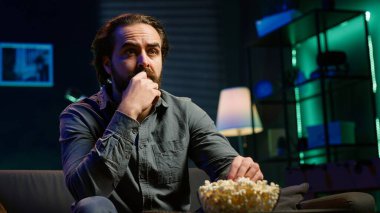 Kafası karışık bir adam yayın servisiyle ilgili kafa karıştırıcı bir film izlerken patlamış mısır yiyor, işten izin almanın keyfini çıkarıyor. Abur cubur yiyen kişi, TV 'de yayınlanan filme karışık entrika ve kamera A ile bakıyor.