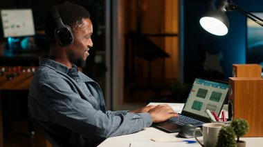 Finans müdürü kulaklıkla müzik yaparak uzaktan muhasebe yapıyor, evdeki bilgisayardaki görevlerini çözüyor. Afrika kökenli Amerikalı adam odaklanmasına yardımcı olmak için en sevdiği şarkı listesiyle birden fazla iş yapıyor. Kamera B.