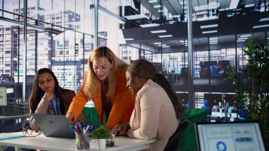 Modern bir işyerindeki kadın yöneticiler iş stratejisi üzerinde işbirliği yapıyor ve verimli bir toplantı düzenliyorlar. Ekonomik bağımsızlığa ve engelleri aşmaya odaklanan başarılı iş kadınları. Kamera B.