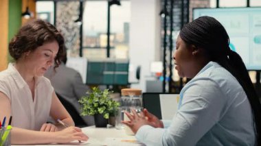 İş görüşmesi sırasında yeni iş sözleşmesini imzalayan siyahi kadın başvuru sahibi, İK müdürü tarafından bölüm ekibine kabul edildi. Evrak anlaşması için imza. Yeni bir başlangıç. Kamera B.