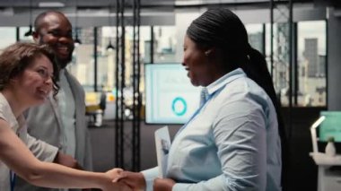 Çeşitli İK ekipleri, kurumsal bir ofiste siyahi bir kadın başvuru ile iş deneyimi ve iş geliştirme nitelikleri hakkında görüşüyor. Seçim için görüşme süreci. Kamera A.