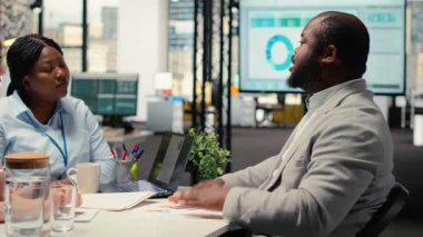 İK çalışanı mülakat sırasında bir adaya bir bardak su dolduruyor, profil ve CV 'yi mükemmel aday seçilmeden önce nitelikleri ve profesyonel deneyimi ile gözden geçiriyor. Kamera B.