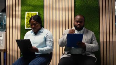 İş görüşmesi ve açık pozisyon için kayıt formlarını dolduran Afrikalı Amerikalı başvuru sahipleri başarılı bir işe alım ve İK ile görüşme sağlıyorlar. Vasıflarını yazıyorum. Kamera A.