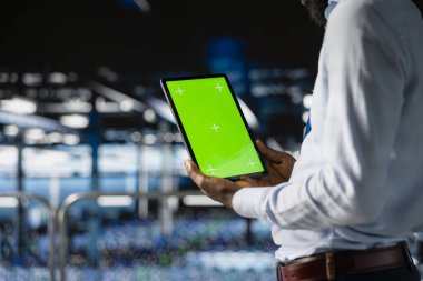 Tabletteki krom anahtarı kullanarak LLM görselleştirmesini gözden geçiren nöral ağı denetleyen erkek teknisyen. Sunucu çiftliği bilişim uzmanı, platformlara güç veren makine öğrenme süreçlerini denetliyor..