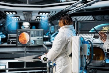 Yörünge istasyonundaki astronot Mars gezegen analizlerini monitörde inceliyor. Uzay gemisi mürettebatı, Mars 'ın gelecekteki gezegen keşiflerine yardımcı olmak için telemetri yazılımı kullanıyor.