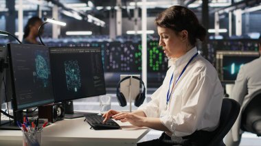 Başarılı yapay zeka konuşlanmasından sonra ofis sandalyelerinde heyecan içinde dans eden neşeli veri merkezi mühendisleri. Gülümseyen sunucu odası arkadaşları başarıyı kutluyor, performans hedeflerine ulaşıyorlar, kamera A