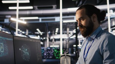 Veri merkezindeki mühendis, iş akışını düzene sokmak ve verimliliği artırmak için çalışma istasyonundaki masa ögelerini yeniden düzenliyor. Görevler sırasında verimliliği optimize etmek için masa başı nesneleri düzenleyen teknisyen, kamera A