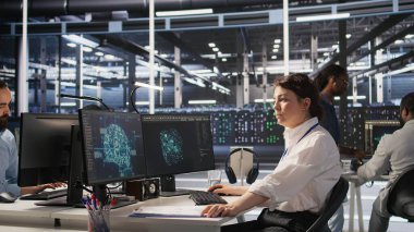 Veri merkezi yazılım geliştiricisi PC kullanarak nöral ağ yapay zeka görüntülemesini izliyor. Sunucu odasında çalışan kadın, donanımlı makine öğrenme işlemlerini denetlemek için bilgisayar kullanıyor, kamera A