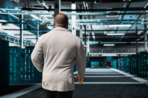 Admin in high tech data center doing checkup to prolong hardware life span protecting against network threats. Server hub IT specialist monitoring infrastructure rigs using automation tools