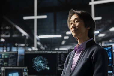 Veri merkezindeki mutlu mühendis, dişli teçhizatların bakımını yapmak için LLM asistanı kullanıyor. Sunucu merkezinde gülümseyen Asyalı adam, yedekleme yapmak için büyük dil model sohbet robotu kullanıyor