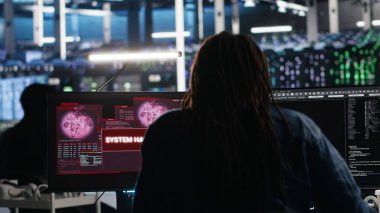Sunucu merkezi yönetimi, donanım sistemlerini güvence altına alırken gizli verilere erişmeye çalışan siber saldırıya yanıt veriyor. Veri Merkezi çalışanı, güvenlik olayı sırasında kötü amaçlı yazılım ihlaliyle mücadele ediyor, kamera B