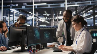 Neşeli veri merkezi ekip lideri başarılı bir altyapı güncellemesinden sonra işçiye beşlik çakıyor. Yapay zeka sistemleri konuşlandırılırken işbirlikçi başarıyı kutlayan memnun iş arkadaşları, kamera A