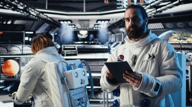 Astronot uzay istasyonu dışında planlanan operasyonlara başlamadan önce görev planını tabletten okuyor. Kozmonot cihazdaki analizleri kontrol ediyor, gezegene indikten sonra ayrılmaya hazırlanıyor.