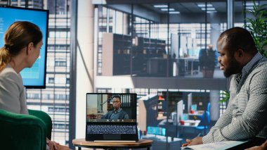 Çok kültürlü bir grup, yönetim kurulundaki bir video konferansında çevrimiçi planlama ve hedef odaklı liderlik tartışmaları yoluyla iş dünyasının başarısına odaklanıyor. Kamera B.