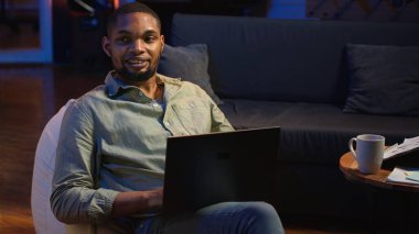 Ürün ve hizmetler hakkında stratejik tavsiyelerde bulunmak için aylık bütçeyi ve harcamaları inceleyen analist. Zenci genç iş adamı gelir dengesi analizi yapıyor, evde muhasebe yapıyor. Kamera B.