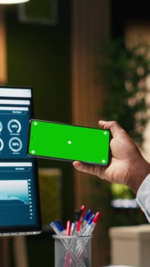 Genel müdürün cep telefonunda bulunan dikey video yeşil ekran görüntüleme ekranı, uluslararası kuruluş için başarı ve verimliliği güvence altına alıyor. Küresel genişleme stratejisi için veriler geç