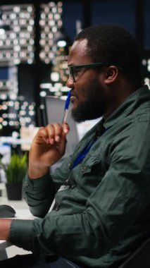 KPI ölçümlerini monitörde ve masaüstünde inceleyen Dikey Video Ofisi çalışanı, hedeflere ve başarıya ulaşmak için bir vizyon ve iş stratejisi oluşturmaktadır. Mesai sonrası profesyonel zihniyet