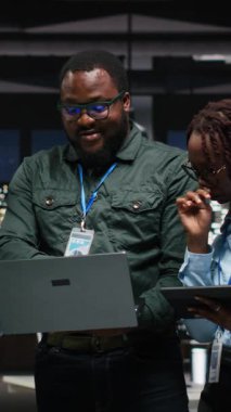 Dikey Video Black şirket personeli ofiste rapor yazma üzerinde birlikte çalışarak yeni bir geliştirme stratejisi oluşturmaya çalışıyor. Verimliliği ve ilerlemeyi arttırmak için görüşler gözden geçiriliyor