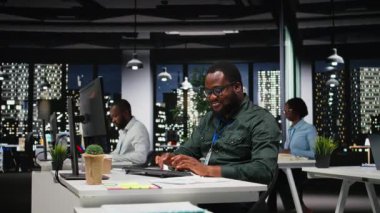 Saatler sonra rakamları ve mali ölçümleri belgeleyen siyah erkek danışman, güncellemeleri araştırıyor ve iş yönetimi gündemini düzenliyor. Hedef ve hedef belirleyen bir adam. Kamera A.