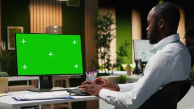 Genç siyahi işadamının verileri incelediği masaüstü bilgisayarında modelleme ekranı, analitik rapor yazma ve küresel genişleme ve iş yönetimi görevleri için çözümler bulma üzerinde çalışıyor. Kamera B.