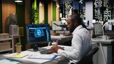Siyahi adam analist veri madenciliği ve optimizasyonu için yapay zeka ağları kullanıyor. Otomasyon araçlarıyla çok uluslu bir şirkette çalışıyor. Başarı için yapay zeka dijital araçları. Kamera A.