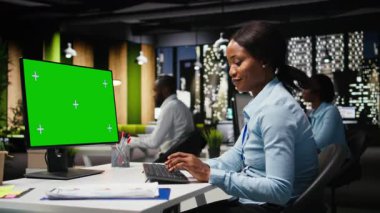 Kadın iş analistinin yanındaki yeşil ekran modeli tahminleri inceliyor, şirketi genişletmek ve performans ölçümlerini artırmak için geliştirme stratejisi geliştiriyor. Profesyonel amaçlar. Kamera A.