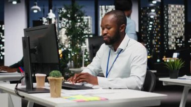 Afrika kökenli Amerikalı bir çalışan, bir ders kitabına büyüme stratejisi notları yazıyor, geceleri anlayış ve finansal verilerle çalışıyor. Danışman operasyonel başarı ve verimliliği garanti ediyor. Kamera B.