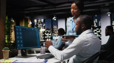 Siyah Bilişim Mühendisleri ekibi bilgisayar üzerinde uygulama ve yazılım algoritması geliştiriyor, gece geç saatlerde ofiste çalışıyorlar. Uzmanlar dijital araçlar kullanır ve senaryo mühendisliği ve kodlamaya odaklanırlar. Kamera A.