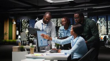 Masaüstünde veri analizlerini inceleyen siyah erkek danışmanlardan oluşan bir ekip, hedeflere ve başarıya ulaşmak için bir vizyon ve iş stratejisi oluşturuyorlar. Gece geç saatlerde takım çalışması için kafa yapısı. Kamera A.