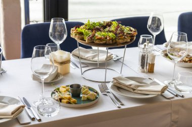 canape with meat and cheese slices on a wooden plate on a served table