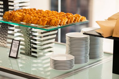 White plates stacked on a catering table at a reception event