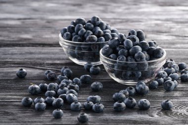 fresh blueberries in bowls on the table, two servings of ripe berries in plates