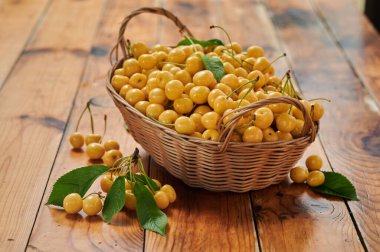 Yellow cherries in a basket on the table, harvest of ripe berries