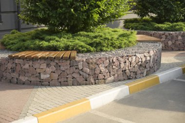 Yol boyunca beyaz ve sarıya boyanmış taş sınırlar arabalar, çalılar ve arazi tasarımındaki bitkiler için.