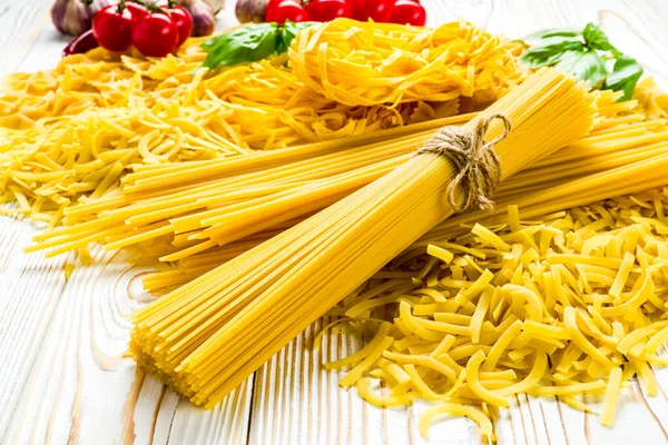 木桌上的小麦子 西红柿和蔬菜制成的意大利面 免版税图库照片