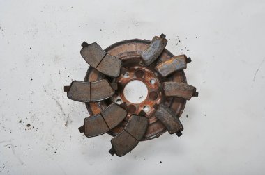 Paslı araba fren balataları ve fren diskleri paslanmış ve arabadan sökülmüş.