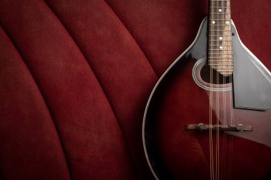Kırmızı bir kanepeye yaslanmış mandolin içerikli arka plan, mesaj için bolca yer var.