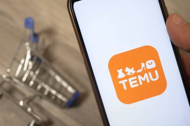 Carrara, İtalya - 10 Haziran 2023 - Yeni e-ticaret servisi Temu 'nun uygulamasını kullanan adam