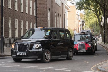 Londra, Uk - 19 Ekim 2024 - Londra 'nın yoğun trafiğinde geleneksel İngiliz taksileri