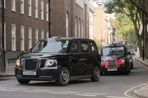 Londra, Uk - 19 Ekim 2024 - Londra 'nın yoğun trafiğinde geleneksel İngiliz taksileri
