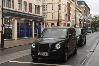 Londra, Uk - 19 Ekim 2024 - Geleneksel İngiliz taksileri Oxford Caddesi 'ne dizildi