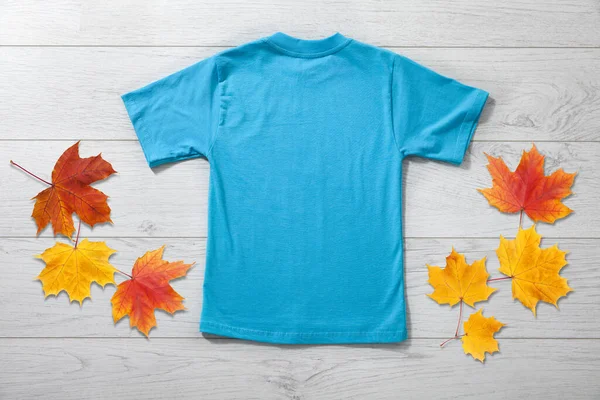白い木製の背景に青のTシャツで小さな男の子のバックビュー デザインクローズアップのためのモックアップ — ストック写真