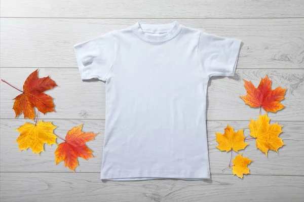 白い木の背景に白いTシャツの小さな男の子のフロントビュー デザインクローズアップのためのモックアップ — ストック写真