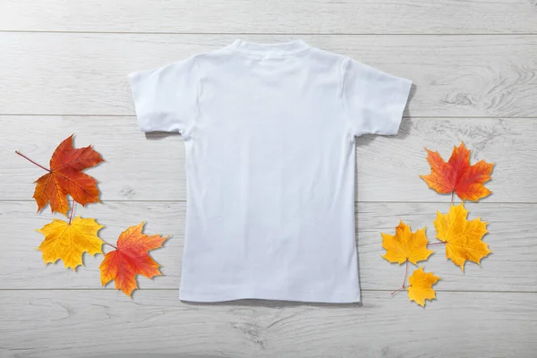 白い木の背景に白いTシャツの小さな男の子のバックビュー デザインクローズアップのためのモックアップ — ストック写真