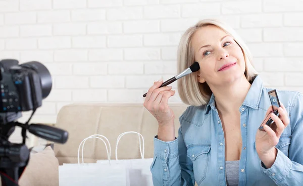 Schöne Frau Beim Make Die Kosmetik Demonstriert Und Sich Hause lizenzfreie Stockfotos