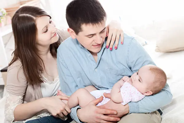 家庭概念 婴儿与爸爸和妈妈 幸福的年轻父母的肖像与婴儿在床上在家里 图库图片
