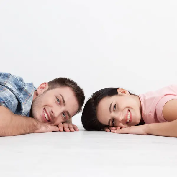 幸福的年轻夫妇 躺在地板上 互相看着对方 梦想着家具为新公寓 模拟设计 图库图片